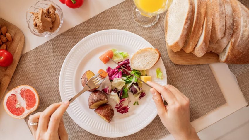 Top view of a nutritious breakfast setup with salad, bread, and fresh juice, perfect for a healthy start.