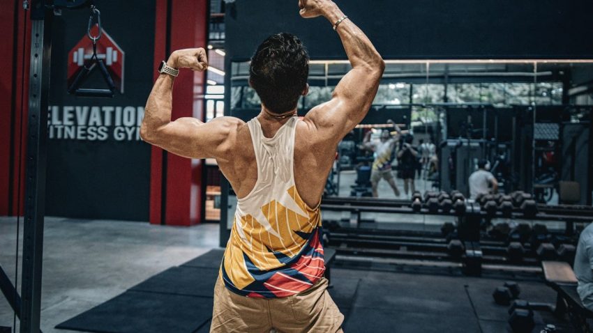 Man flexes muscles in a gym